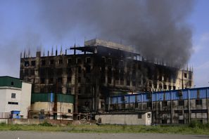 Rök stiger från den fabrik där en dödlig brand bröt ut utanför Dhaka, Bangladesh på fredagen. Mahmud Hossain Opu/AP/TT.