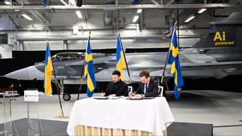 Ukrainas president Volodymyr Zelenskyj och Sveriges statsminister undertecknar onsdagen den 22 oktober 2025 en avsiktsförklaring om JAS-39 Gripen E till Ukraina, det svenska stridsflygplan framför vilket de sitter. Foto: Fredrik Sandberg / TT