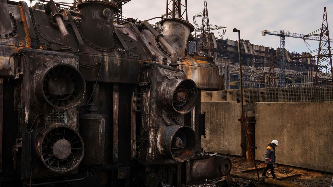 En ukrainsk energiarbetare promenerar den 28 november 2024 bredvid en transformatorstation som förstördes av en rysk kryssningsrobotattack mot ett kraftverk till hörande den ukrainska energijätten DTEK. Foto: AP Photo/Evgeniy Maloletka