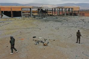 Anhängare till den nya syriska regeringen framför en skadad militär byggnad utanför Syriens huvudstad Damaskus i måndags. Ghaith Alsayed/AP/TT