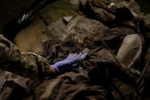 En ukrainsk soldat undersöker kvarlevorna efter en stupad rysk soldat i Slovjansk i östra Ukraina i fjol. Bram Janssen/AP/TT