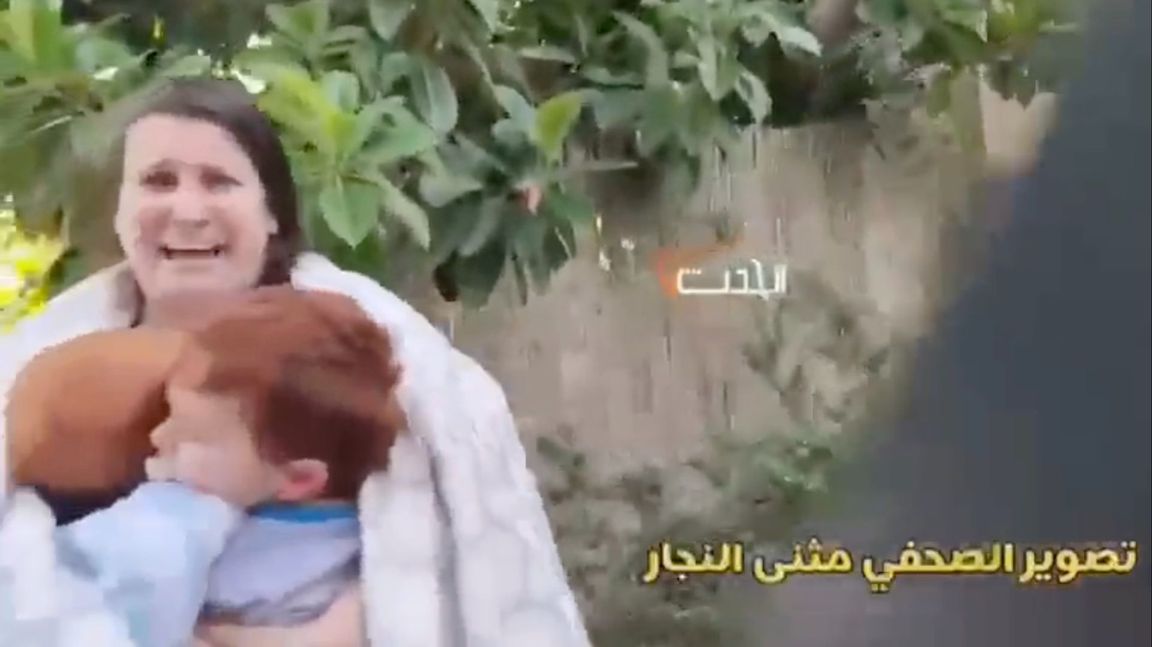 En israelisk mamma med två barn på famnen innan de mördas eller förs bort av Hamas, från Hamas egen video av massakern. De försöker inte dölja något och merparten av deras videos är mycket värre. Skärmdump från X.