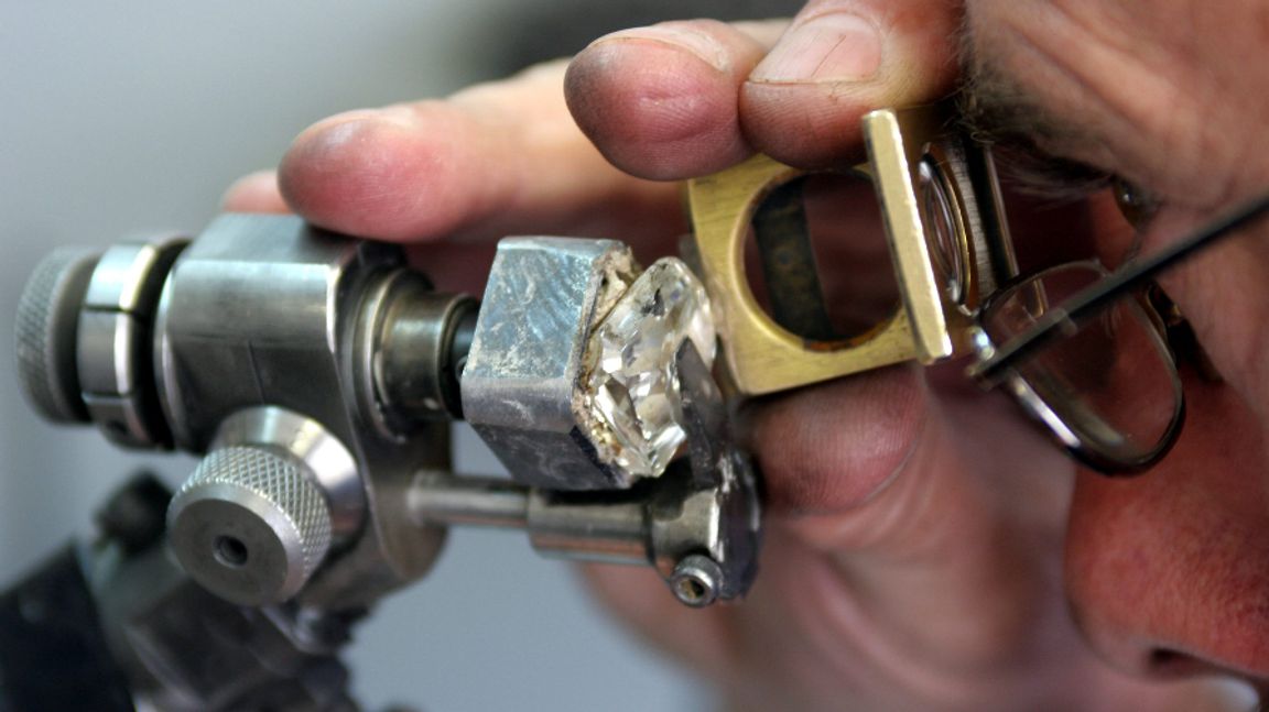 En äkta sydafrikansk diamant inspekteras. Tyvärr visade sig stenarna i KwaHlathi som lockade tusentals diamantletare vara av kvarts. Foto: Denis Farrell/AP/TT