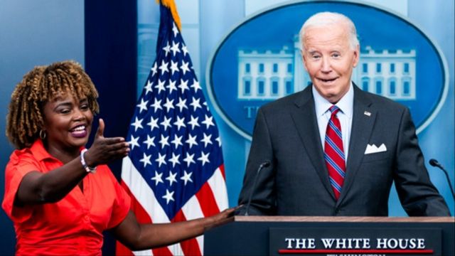 Pressekreteraren Karine Jean-Pierre tycks hålla i Joe Biden under en pressträff. Foto: AP