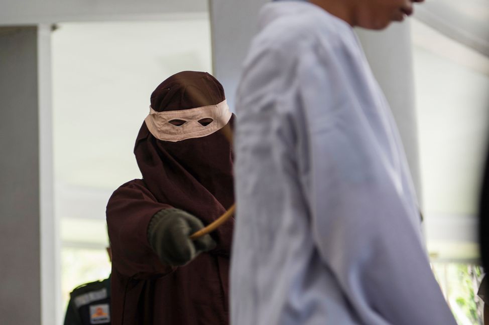 En shariapolis piskar en av de två dömda männen i Banda Aceh på torsdagen. Foto: Reza Saifullah/AP/TT