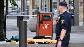 Polisen vid avspärrningarna efter att fyra personer hittats med skottskador i Farsta i södra Stockholm på lördagen. Två personer har hittills avlidit. Foto: Anders Wiklund//TT