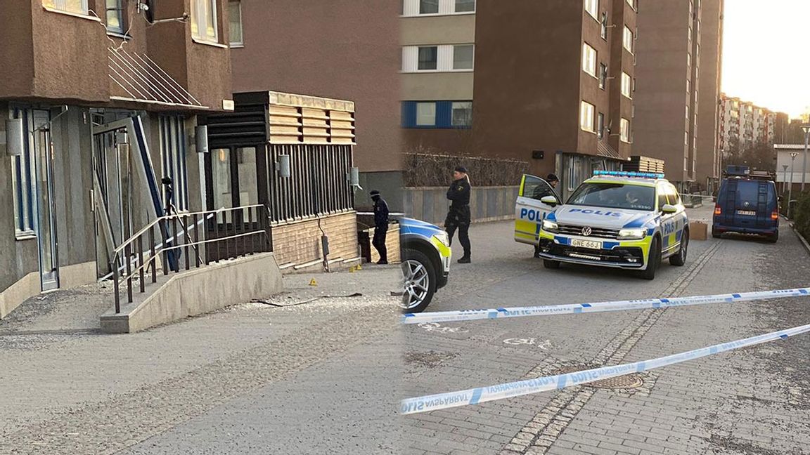 Den bortbåsta porten efter explosionen i Akalla under natten till fredagen, samt polisens avspärrningar i området kring huset. Foto: Isabelle Eriksson