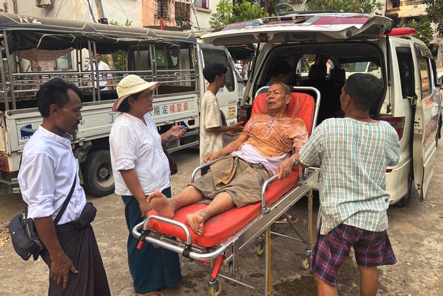 En skadad man förs till sjukhus efter att ha varit fast i en raserad byggnad i Myanmars huvudstad Naypyitaw. Aung Shine Oo/AP/TT
