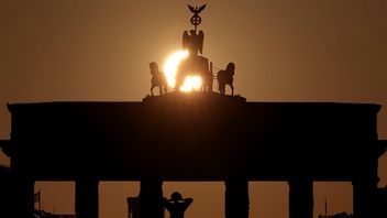 Solen stiger över ikoniska Brandenburger Tor i Berlin. Foto: Michael Sohn/AP/TT