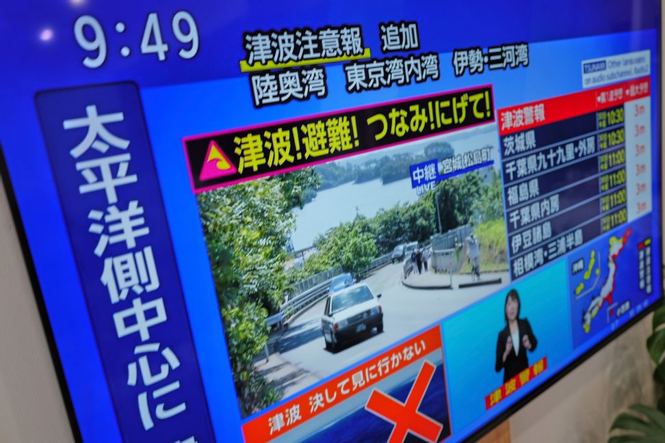 En tsunamivarning visas på en tv i Yokohama, nära Tokyo. Foto: Eugene Hoshiko/AP/TT