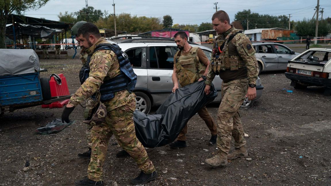 Ukrainsk militär bär på ett offer från attacken i Zaporizjzja. Foto: Leo Correa/AP/TT  