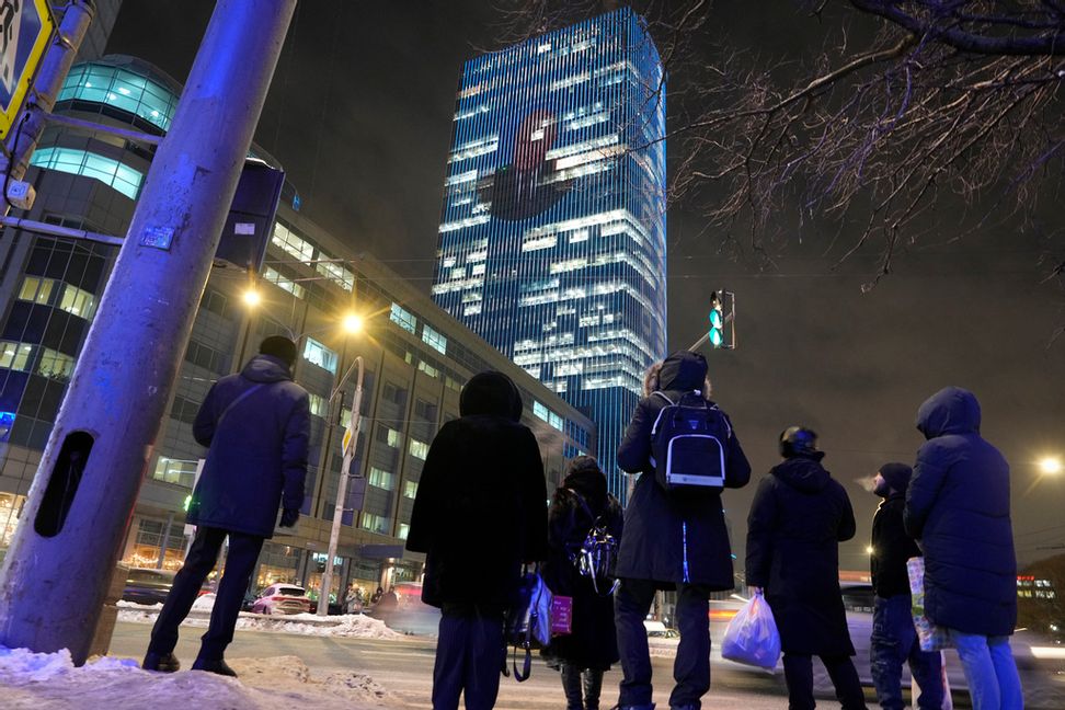 Vladimir Putins ansikte projiceras på en kontorsbyggnad i Moskva i samband med att han håller sin årliga presskonferens. Foto: Dmitrij Lovetskij/AP/TT