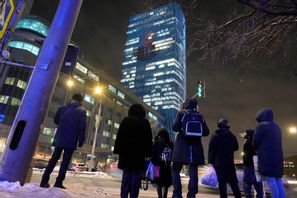 Vladimir Putins ansikte projiceras på en kontorsbyggnad i Moskva i samband med att han håller sin årliga presskonferens. Foto: Dmitrij Lovetskij/AP/TT