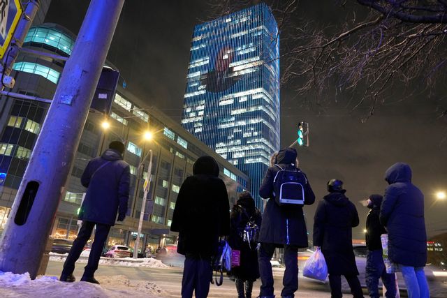 Vladimir Putins ansikte projiceras på en kontorsbyggnad i Moskva i samband med att han håller sin årliga presskonferens. Foto: Dmitrij Lovetskij/AP/TT