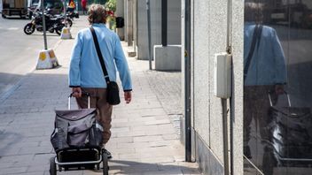 Kvinna drar en shoppingvagn, Stockholm. Foto: Fotograferna Holmberg/ TT/