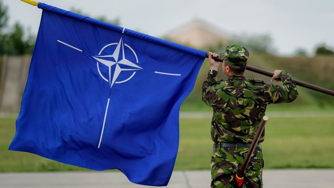 En rumänsk soldat håller i Nato-flaggan. Foto: Vadim Ghirda/AP/TT 