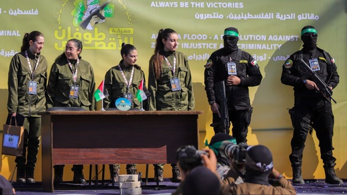 Arkivbild från ett tidigare gisslansläpp. Notera att den kvinnliga gisslan tvingas hålla upp ”goodie bags” från Hamas. Foto: AP