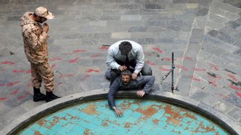 Soldat från Islamiska revolutionsgardet med en fånge. Foto: Ebrahim Noroozi/AP/TT