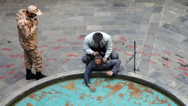 Soldat från Islamiska revolutionsgardet med en fånge. Foto: Ebrahim Noroozi/AP/TT