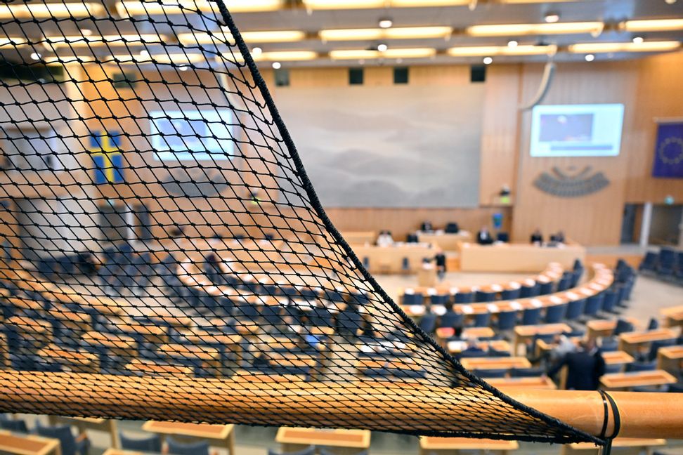 Ett nät har satts upp vid delar av åhörarläktaren i riksdagen. Henrik Montgomery/TT