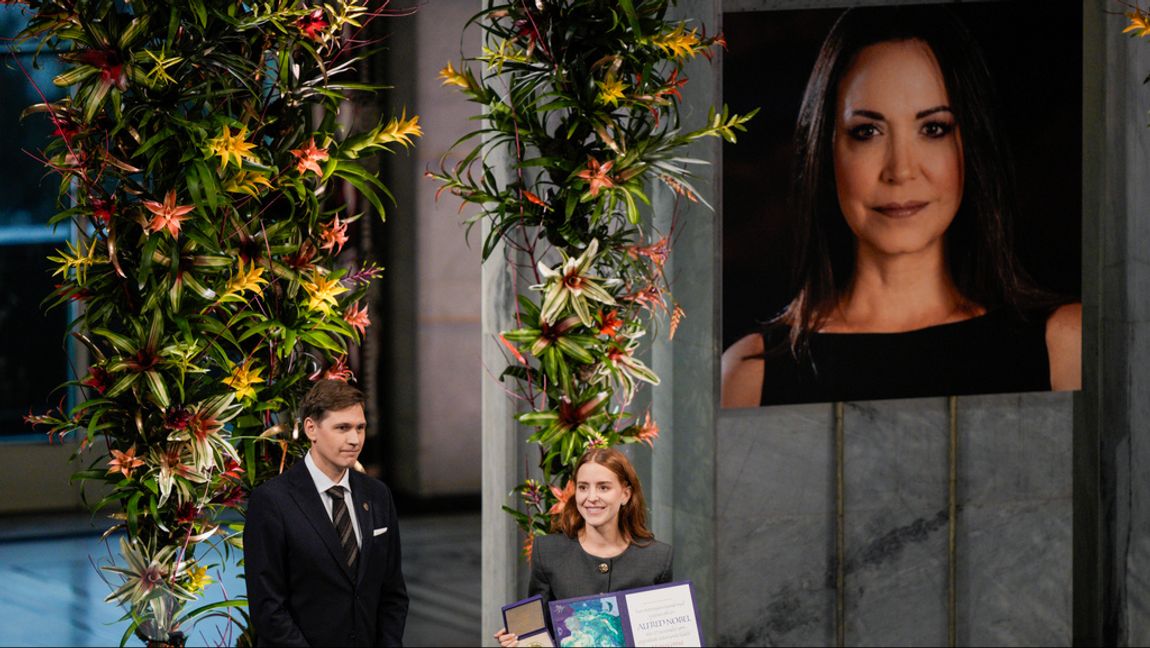 Ana Corina Sosa tar emot Nobels fredspris å sin mors vägnar på onsdagen. I bakgrunden ett fotografi av María Corina Machado. Foto: Stian Lysberg Solum/NTB/TT