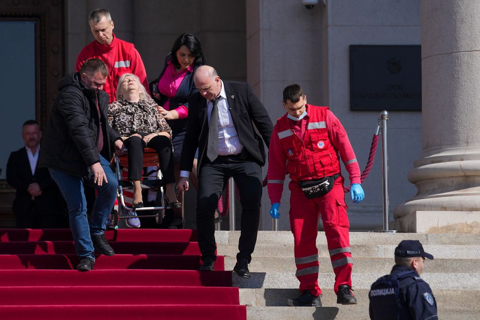 En skadad förs till vård efter kaoset i parlamentet. Darko Vojinovic/AP/TT