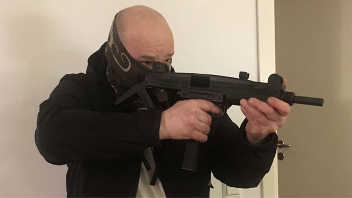  Henry Gergi poserar med en kulsprutepistol. Foto: Polisen 