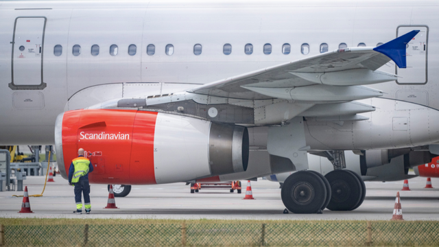 En tekniker arbetar på ett SAS-flygplan som står parkerat på Kastrups flygplats på måndagskvällen, efter att pilotstrejken inletts. Foto: Johan Nilsson/TT 