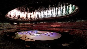 Lågmälda fyrverkerier inför tomma läktare vid gårdagens OS-invigning på Tokyos Olympiastadion. Foto: Patrick Semansky/AP/TT 