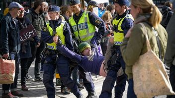 Polisen bär iväg en annan klimataktivist efter en trafikblockad i Stockholm april 2022. Foto: Janerik Henriksson / TT