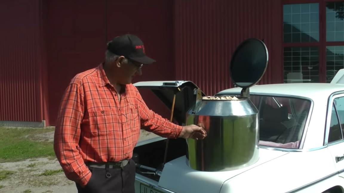 Gunnar Persson visar upp sin Mercedes som han byggt om till en gengasbil med vedtank. Foto: Skärmdump Youtube