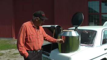 Gunnar Persson visar upp sin Mercedes som han byggt om till en gengasbil med vedtank. Foto: Skärmdump Youtube