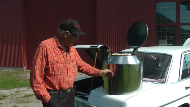 Gunnar Persson visar upp sin Mercedes som han byggt om till en gengasbil med vedtank. Foto: Skärmdump Youtube