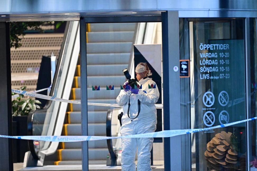 Polisens tekniker och ett skotthål vid entrén till köpcentret Kungsmässan i Kungsbacka efter att en person blev skjuten under söndagen. Foto: Björn Larsson Rosvall/TT