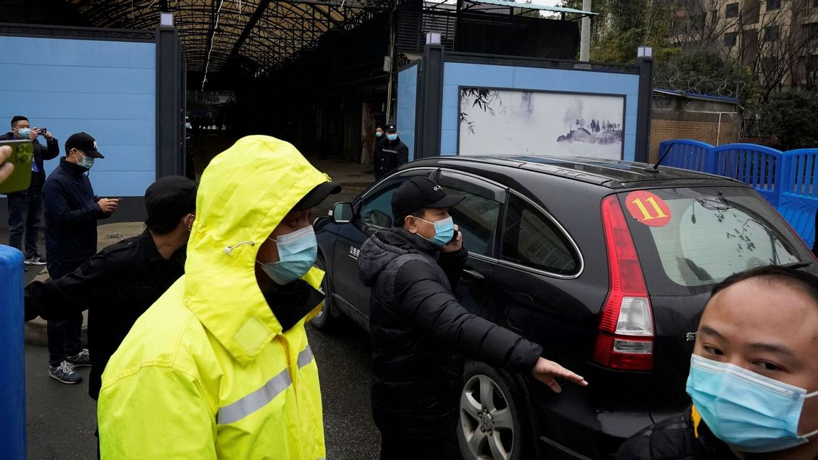 In this file photo dated Sunday, Jan. 31, 2021, security personnel clear the way for a convoy of the World Health Organization team to enter the Huanan Seafood Market on the third day of field visit in Wuhan in central China’s Hubei province. In a commentary published Wednesday Aug. 25, 2021, the international scientists dispatched to China by the World Health Organization to look for the origins of the coronavirus say the search has “stalled” and warn the window is closing to conduct critical studies that could provide clues on how the virus first infected people. Photo: Ng Han Guan/AP/TT