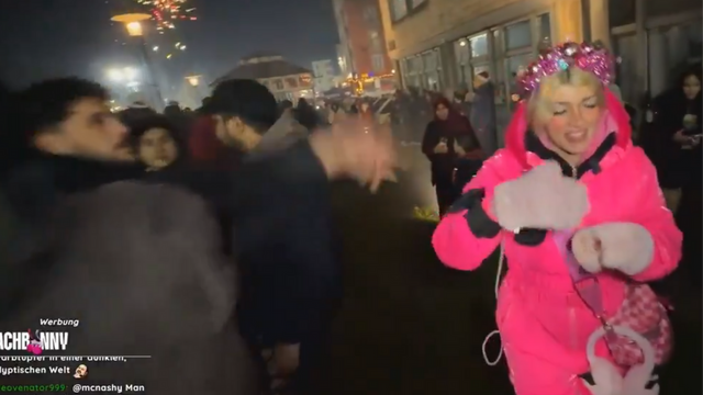 Mannen till vänster kastar något typ av föremål på Kunshikitty. Foto: Skärmdump X