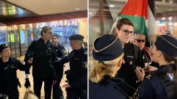 Fyra poliskvinnor för bort en man med israelisk flagga. Foto: X