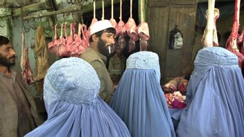 Kvinnor i burka på en marknad i Kabul. Medan utlandsafghaner återvänder för shopping i lyxbutiker lever lokala kvinnor under talibanernas hårda restriktioner. Foto: Kamran Jebreili/AP/TT