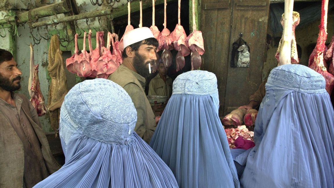 Kvinnor i burka på en marknad i Kabul. Medan utlandsafghaner återvänder för shopping i lyxbutiker lever lokala kvinnor under talibanernas hårda restriktioner. Foto: Kamran Jebreili/AP/TT
