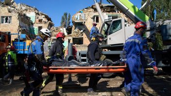 Ukrainska räddningstjänstmedarbetare bär bort ett dödsoffer framför ett bostadshus som skadades i den ryska attacken mot Kiev den 28 augusti 2025. Foto: AP Photo/Efrem Lukatsky