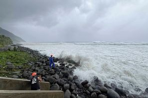 Människor tittar på när stora vågor drar in mot provinsen Batanes i norra Filippinerna under måndagen till följd av en omfattande tyfon. Foto: Justine Mark Pillie Fajardo/AP/TT