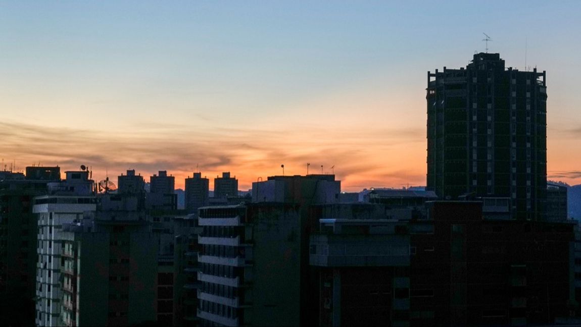 Mörklagda byggnader i Caracas på fredagsmorgonen. Foto: Ariana Cubillos/AP/TT