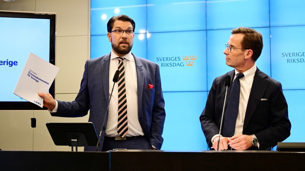 Jimmie Åkesson håller upp den nya regeringsöverenskommelsen. Foto: Jonas Ekströmer/TT