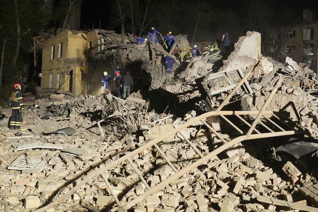 Ukrainsk räddningspersonal söker i rasmassorna natten till torsdag efter en rysk robotattack. Foto: Efrem Lukatsky/AP/TT