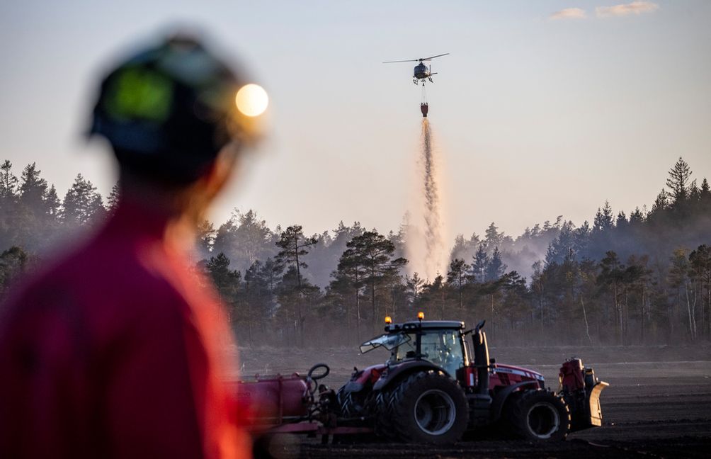 Räddningstjänsten i Halland oroas över hur värme och vind ska påverka branden i en torvtäkt i Hylte som bröt ut förra veckan och fortfarande pågår. Foto: Johan Nilsson / TT