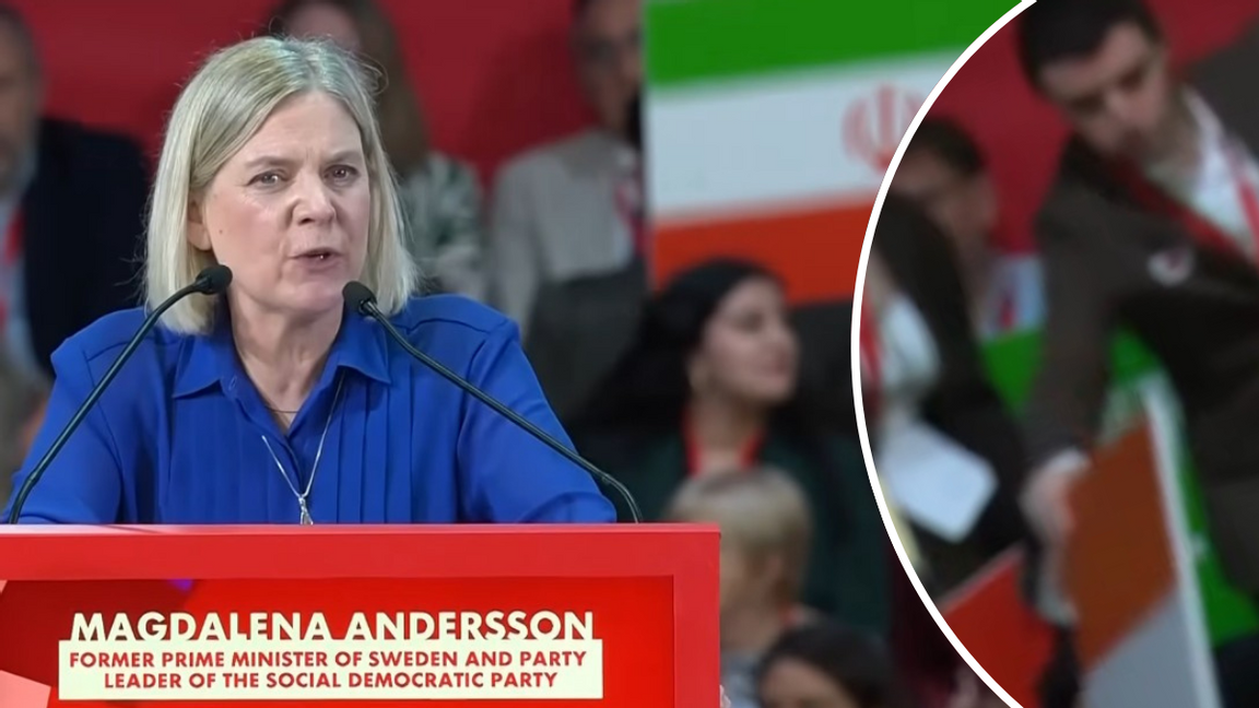 Magdalena Andersson (S) talar vid vänsterkonferensen i Barcelona. I bakgrunden syns personer som ser ut att dela ut plakat i form av flaggor till publiken. Foto: Yotube/Skärmdump
