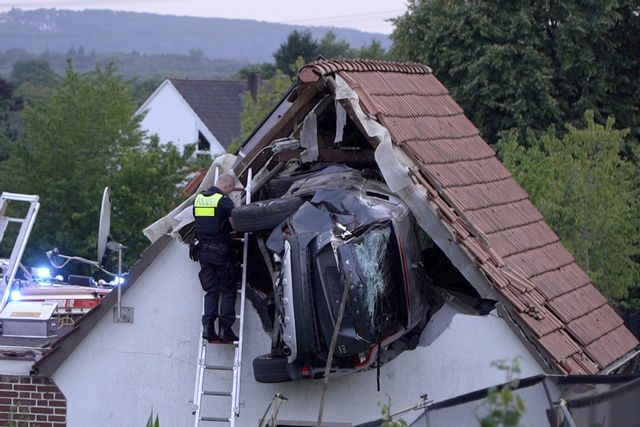 Polisen undersöker bilen som kraschat in i ett tak på en lada i nordvästra Tyskland på söndagen. Foto: Torben Kipp/AP/TT
