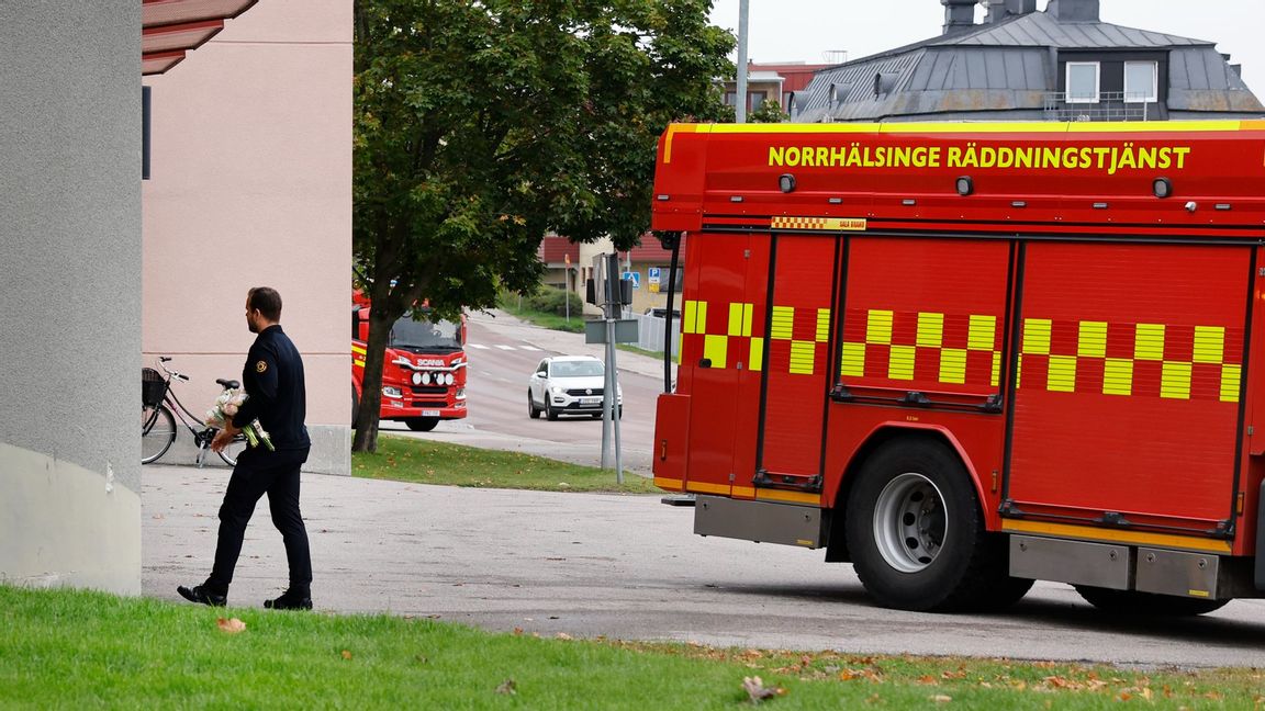 Räddningstjänstpersonal lämnar blommor vid ambulansstationen i Hudiksvall efter att en ambulanssjukvårdare dödades i tjänsten. Foto: Mats Andersson/TT