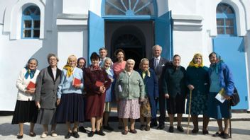 Sveriges kung och drottning framför kyrkan i Gammalsvenskby vid statsbesök 2008, omgivna av några av de sista svensktalande i byn. Foto: Henrik Montgomery/TT