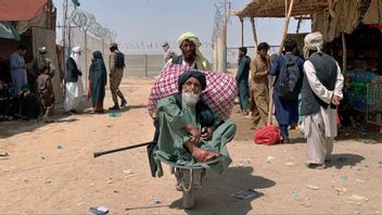 En äldre afghansk man transporteras på en skottkärra vid gränsövergången i Chaman i Pakistan den 20 augusti. Foto: AP/TT.